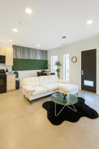 a living room with a white couch and a table at Forestline Suite in Des Moines