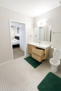 a bathroom with a sink and a toilet and a bed at Forestline Suite in Des Moines +26 photos
