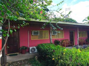a red house with a porch and a patio at Cabinas Marcelina in Puerto Jiménez