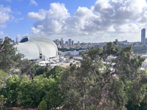 a view of a large building in a city with trees at Carnatal Agora- 30m da Arena das Dunnas in Natal