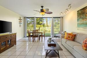 a living room with a couch and a flat screen tv at The Beach Nook at Turtle Bay in Kahuku