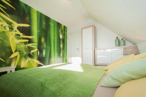 a bedroom with a green bed and a mirror at Ferienwohnung Nilsson in Halstenbek