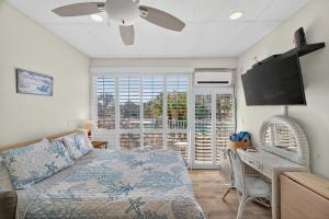 een slaapkamer met een bed en een flatscreen-tv bij Belleview Gulf Unit 395 in Clearwater Beach
