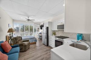 een keuken en een woonkamer met een bank en een bed bij Belleview Gulf Unit 395 in Clearwater Beach