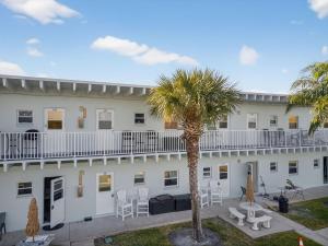 een wit gebouw met een palmboom ervoor bij Belleview Gulf Unit 395 in Clearwater Beach
