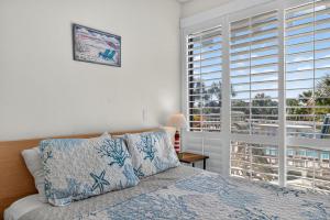 een slaapkamer met een bed en een groot raam bij Belleview Gulf Unit 395 in Clearwater Beach
