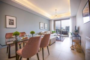 una sala de estar con una mesa, sillas y un sofá en Nautica 2-BR Apt & Balcony at Waterfront in Dbaye, en Dbayeh