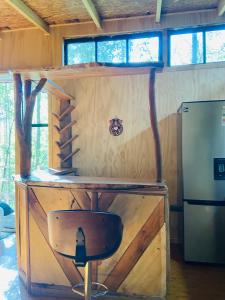 una piccola cabina con una scrivania e un frigorifero di Cabañas con Tinajas Mahuidas Panguipulli a Panguipulli