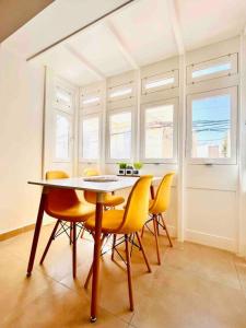 una sala da pranzo con un tavolo e sedie gialle di Sunny house by the sea a Taʼ Xbiex