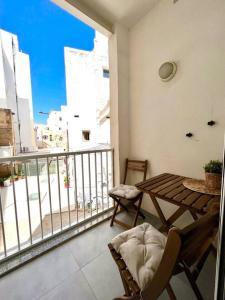 un balcone con tavolo e sedie su un edificio di Sunny house by the sea a Taʼ Xbiex