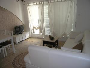 un salon avec un canapé blanc et une télévision dans l'établissement Apartment Damijan, à Krk