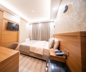 a hotel room with a bed and a television at Zirvesta Otel in Istanbul