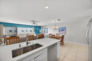 a kitchen with a sink and a dining room at Captains Cove Unit 402 in Clearwater Beach