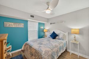a bedroom with a bed and a ceiling fan at Captains Cove Unit 402 in Clearwater Beach +36 photos
