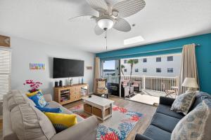 a living room with a couch and a flat screen tv at Captains Cove Unit 402 in Clearwater Beach