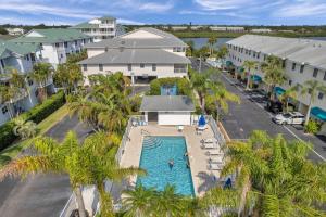an aerial view of a resort with a pool and palm trees at Captains Cove Unit 402 in Clearwater Beach