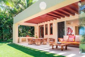 an outdoor patio with a couch and tables and chairs at Ocean view villa- home Infinity Pool Concierge in Punta Mita
