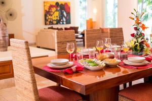 a wooden table with wine glasses and food on it at Ocean view villa- home Infinity Pool Concierge in Punta Mita