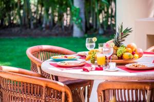 a table with a plate of fruit and wine glasses at Ocean view villa- home Infinity Pool Concierge in Punta Mita +29 photos