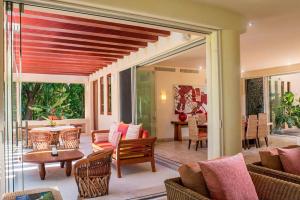 a room with a patio with chairs and a table at Ocean view villa- home Infinity Pool Concierge in Punta Mita
