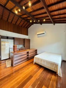 a bedroom with a bed and a kitchen at Atelier-homeoffice in Pirenópolis