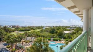 a balcony with a view of a pool and palm trees at Inn at Seacrest Beach 408 in Rosemary Beach +19 photos