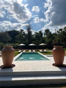 two large vases are sitting next to a swimming pool at Quinta da Bocaina in Amparo