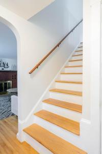 Una escalera en una casa con paredes blancas y suelos de madera. en Spacious 4 bedroom home with large yard, en Wayland