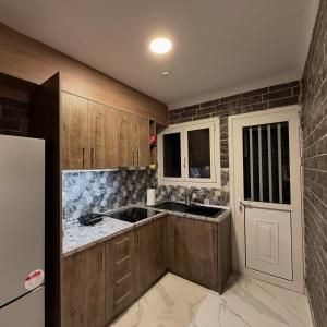 a kitchen with wooden cabinets and a sink at Aphrodite Apartment in Athens