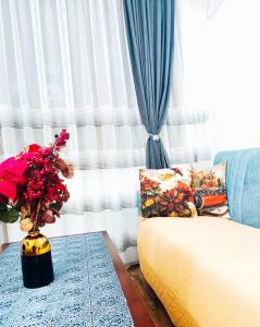 a living room with a couch and a vase with flowers at Diamond Heights apartament in Bansko