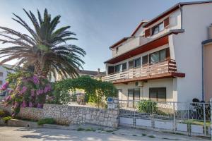 a house with a palm tree in front of it at Apartment Palma in Mali Lošinj