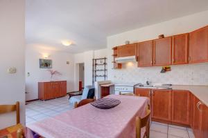 a kitchen with a table and a dining room at Apartment Palma in Mali Lošinj