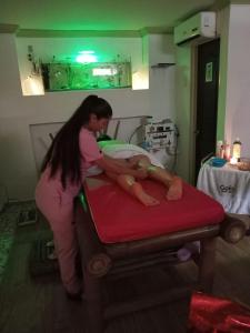 uma mulher colocando um bebê em uma cama em um hospital em HOTEL NOGAL PLAZA em La Virginia