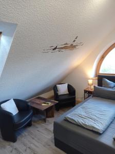 Una sala de estar con una cama, una mesa y sillas. en Gästezimmer Öcken, en Neuharlingersiel