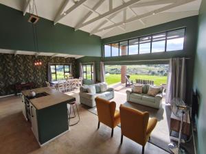 a living room with green walls and a table and chairs at Beautiful Breakaway in Champagne Valley