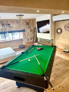 a pool table in a room with a pool cue at Boutique apartment in heart of Haifa in Haifa
