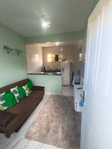 a living room with a couch and a kitchen at Recanto do Coral in Cabo Frio +83 photos