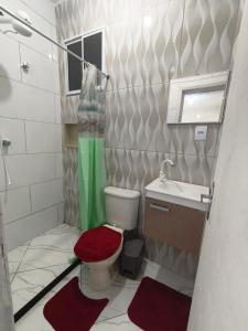 a small bathroom with a toilet and a sink at Recanto do Coral in Cabo Frio