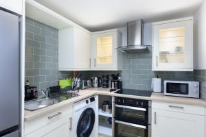 a kitchen with white cabinets and a sink at Perfect 3 Bedroom Banbury Accommodation for Contractors! in Banbury +31 photos