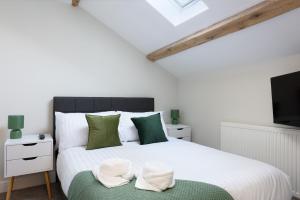 a bedroom with a large white bed with green pillows at Perfect 3 Bedroom Banbury Accommodation for Contractors! in Banbury