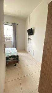 um quarto com uma cama e uma televisão em Hotel Colombo em São Lourenço