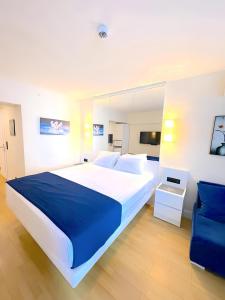 a bedroom with a large bed and a blue chair at Aparthotel In orbi City in Batumi