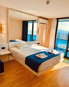 a bedroom with a large bed with a large window at Aparthotel In orbi City in Batumi