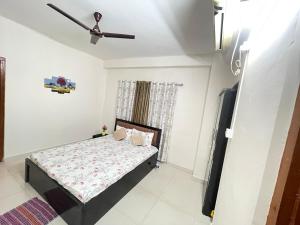 Un dormitorio con una cama y un ventilador de techo. en A2 Homestay, en Guwahati
