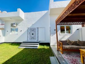 a white house with a couch and grass at Quiet Villa in Luxor