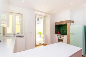 una cucina con pareti bianche e frigorifero di Pateo Boaventura in Bairro Alto a Lisbona