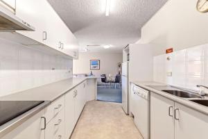 コフスハーバーにあるSeaside Escape Sandcastles 213の白いキャビネットとシンクのあるキッチン