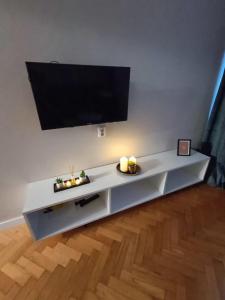 a white entertainment center with a flat screen tv on a wall at Apartament Aksamitny in Toruń