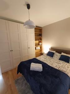 a bedroom with a large bed with a blue blanket at Apartament Aksamitny in Toruń +12 photos