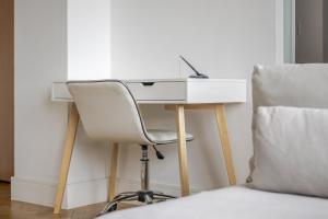 a white desk with a chair next to a bed at Parkway House in Chelmsford